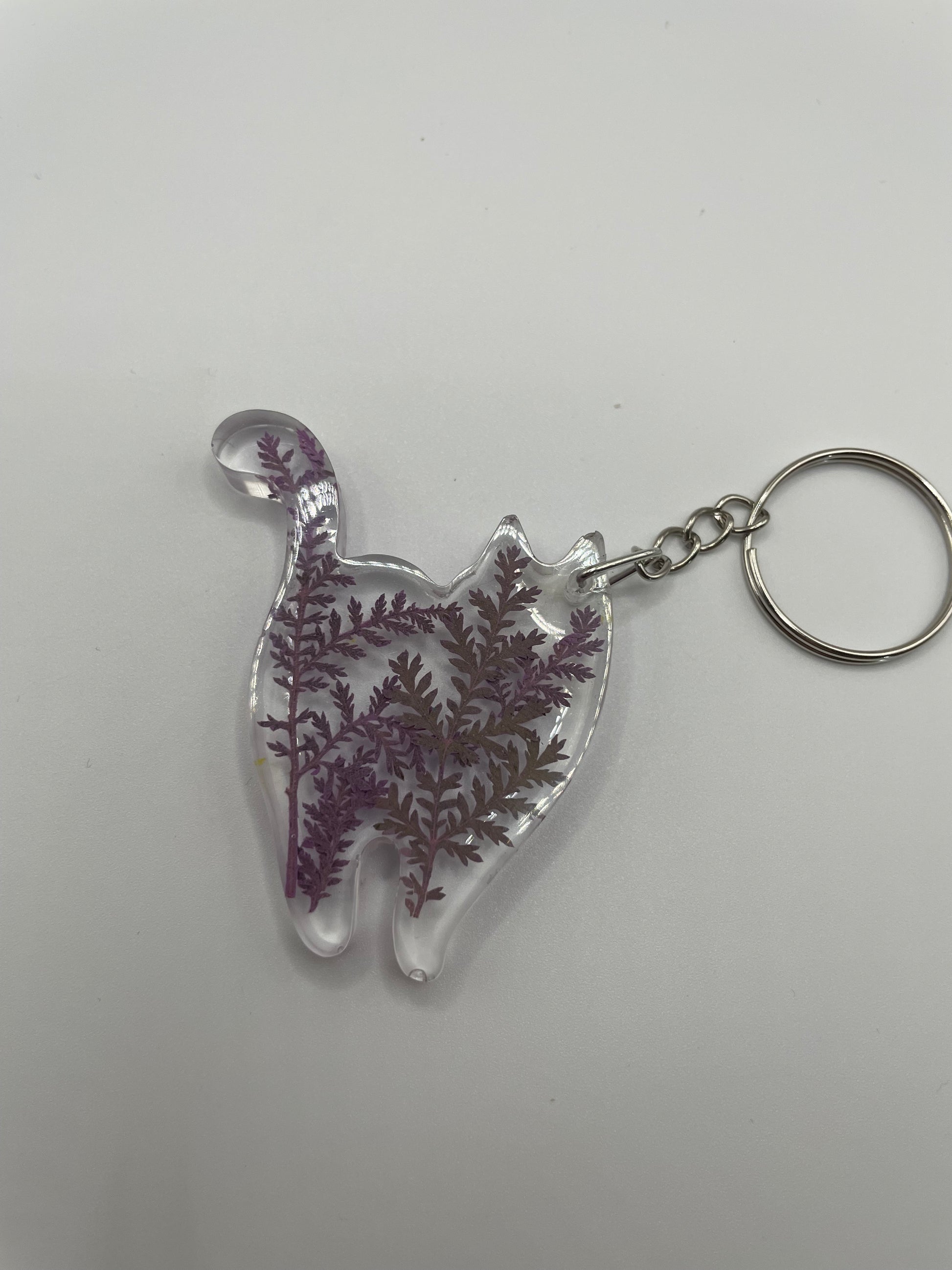 Clear keychain with purple leaf design on a white background