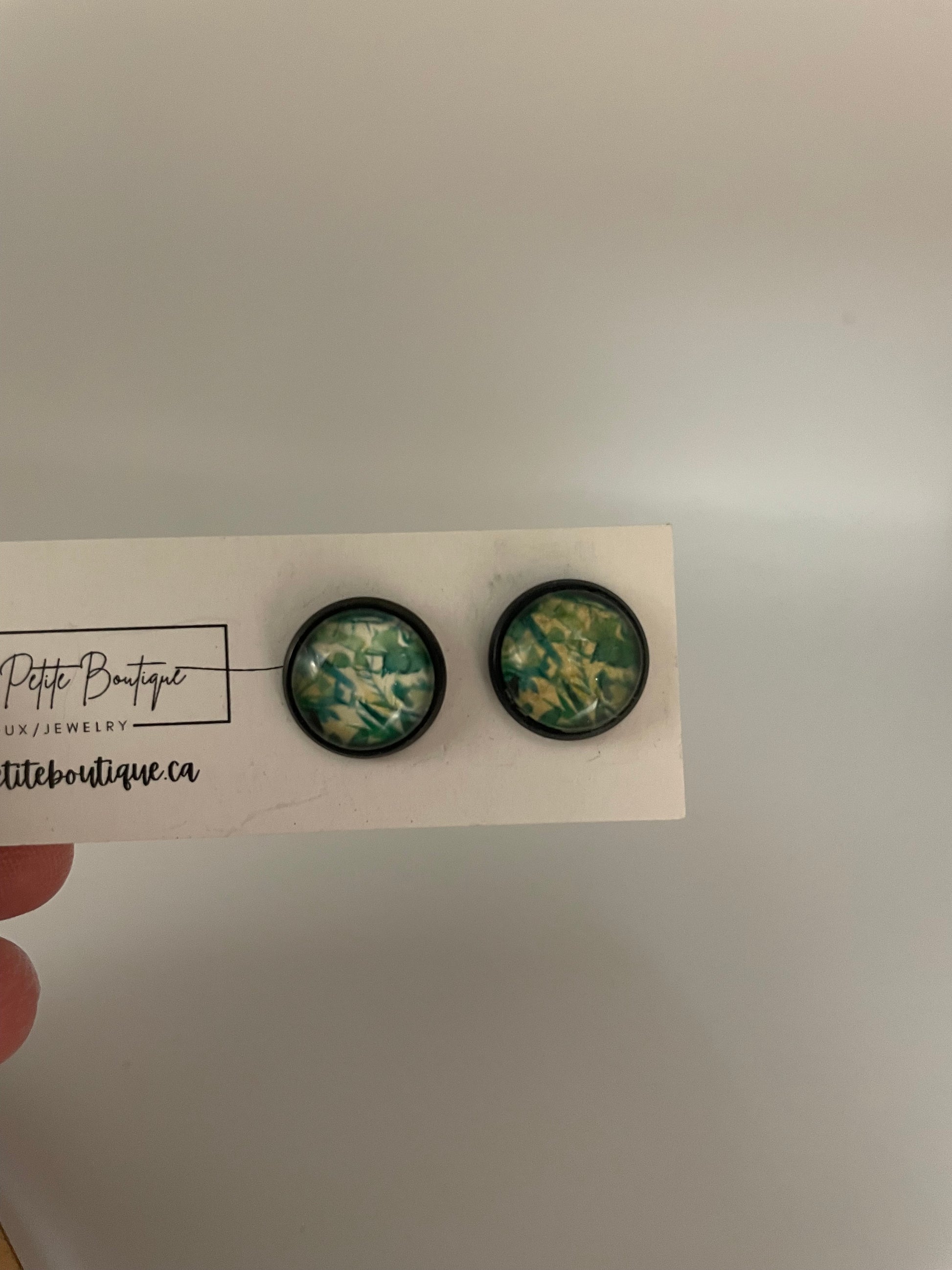 Two floral-patterned buttons on a card held by a hand with a neutral background