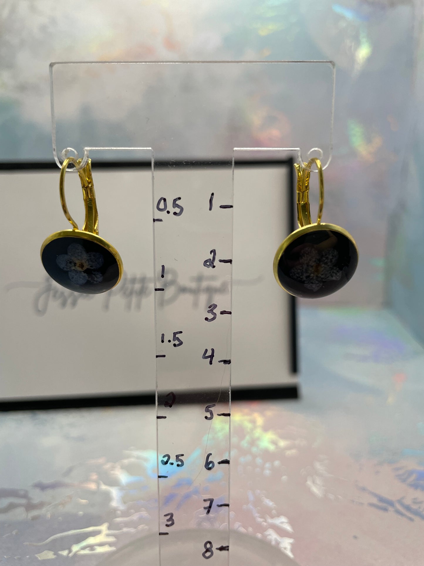 Boucles d’oreilles dormeuse or avec fleur de myosotis sur noir