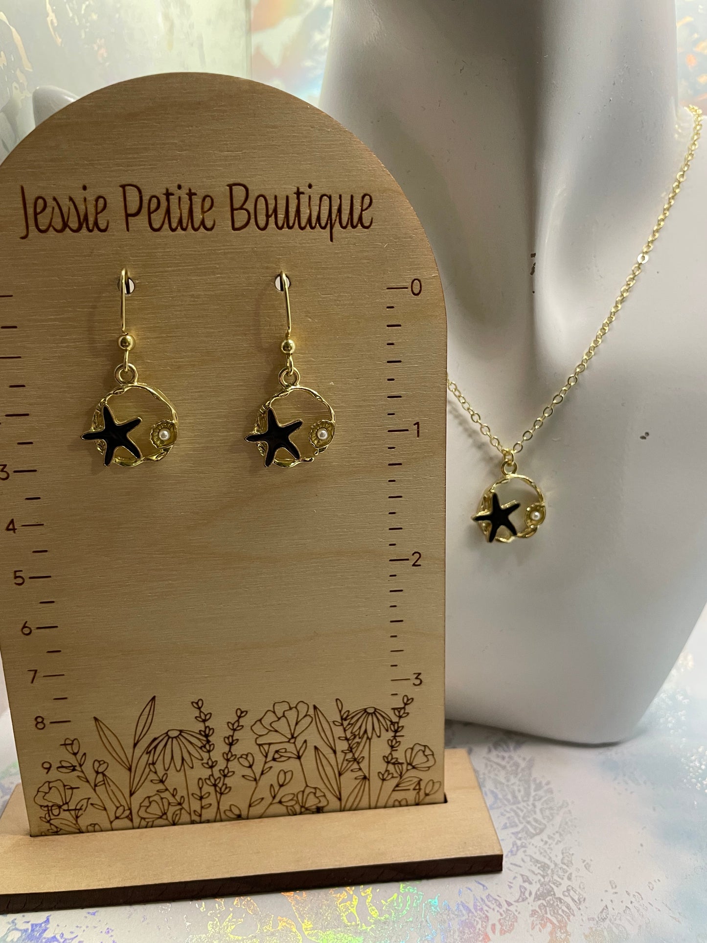 Étoile de mer noire sur cercle doré avec perles