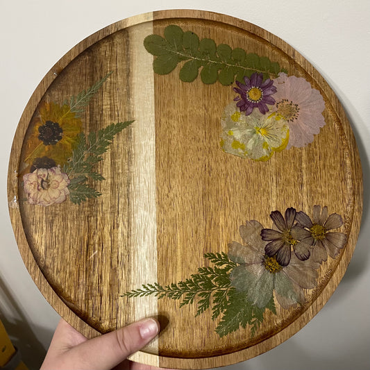 dried flowers on a round wooden tray