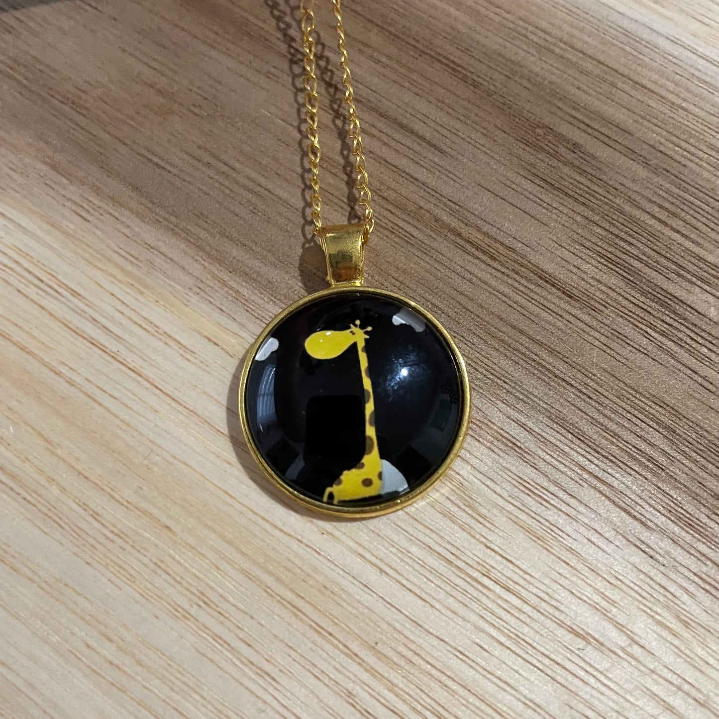 Collier giraffe dans un cabochon dorée