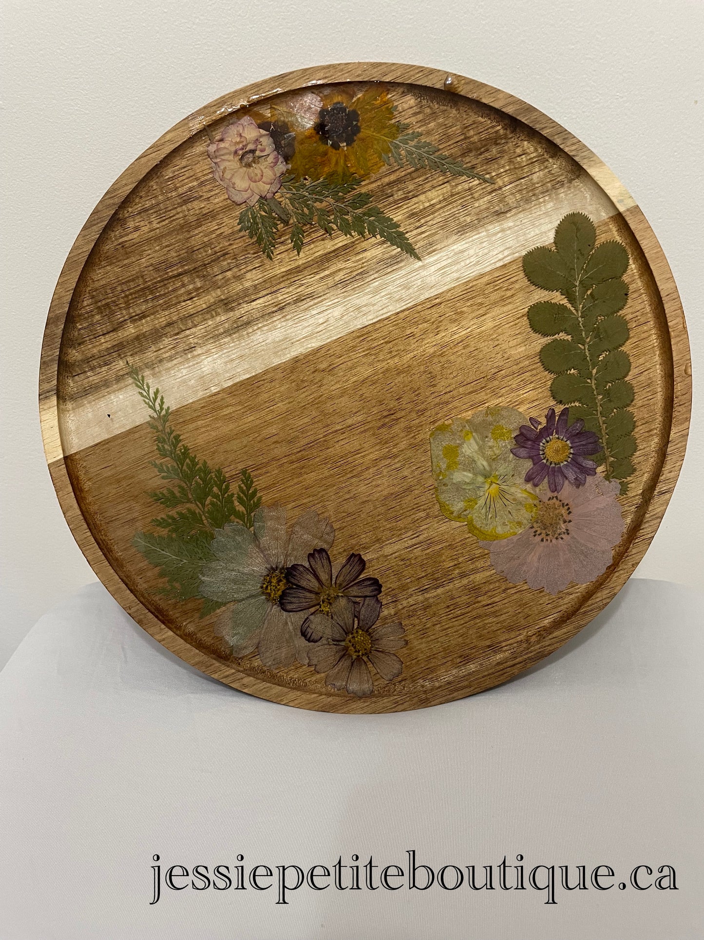 dried flowers on a round wooden tray