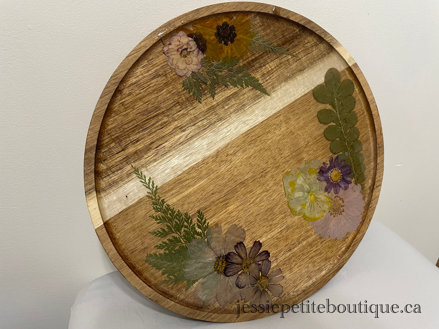 dried flowers on a round wooden tray