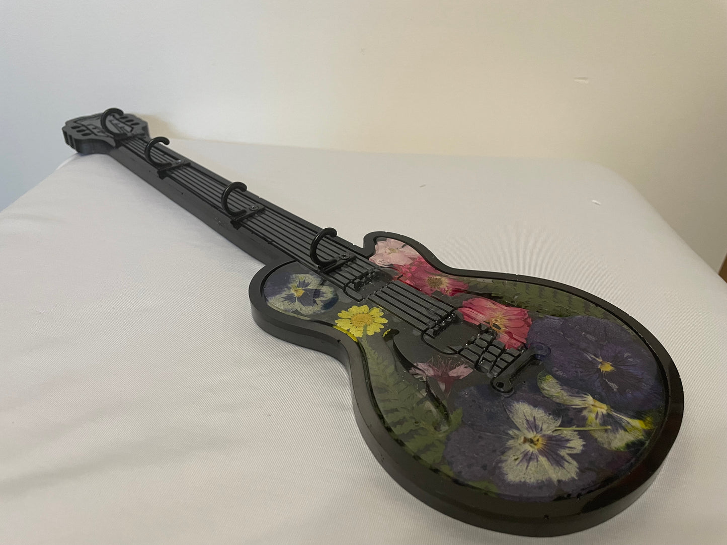 Floral-patterned guitar-shaped object on a white surface