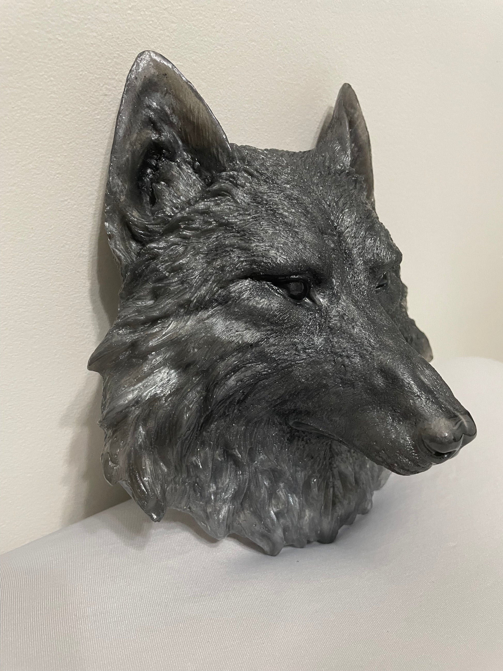 Metallic wolf head sculpture on a white background