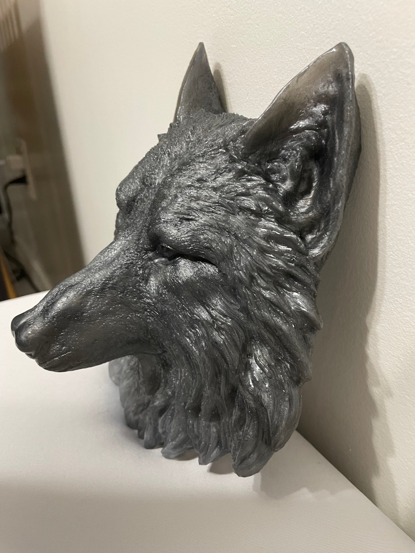 Decorative wolf head sculpture on a white surface