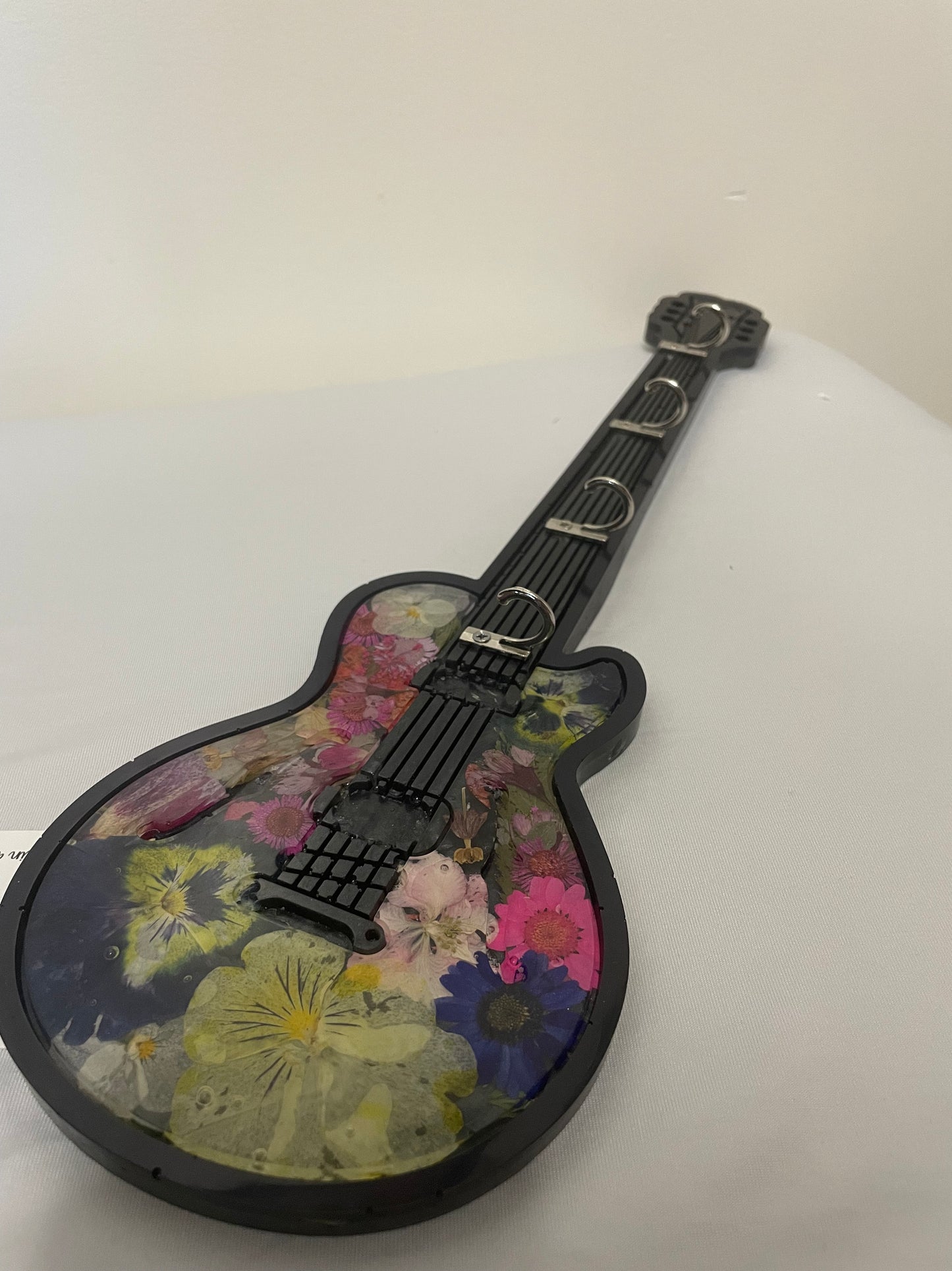 Decorative guitar with floral patterns on a plain background