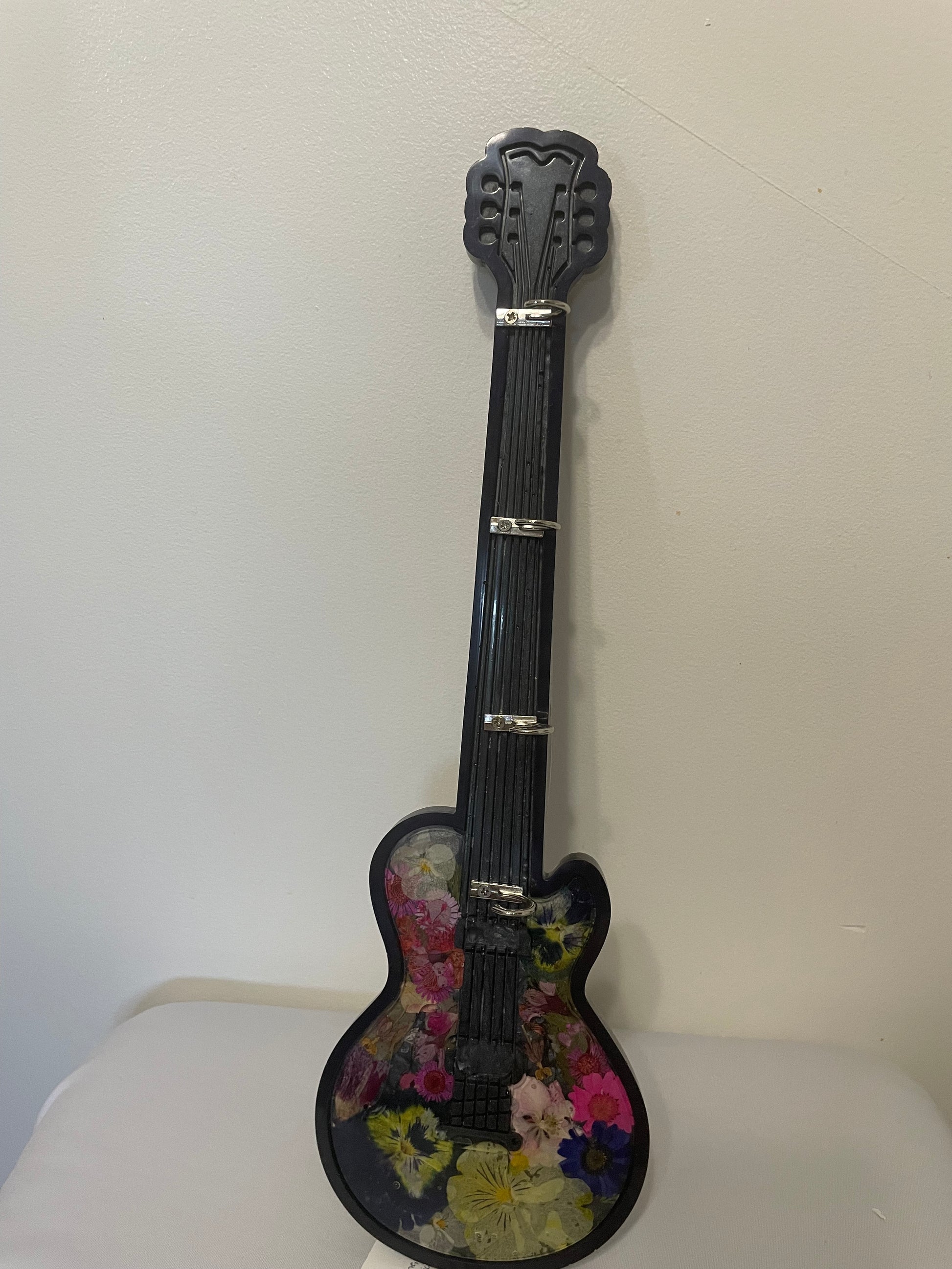 Small guitar with floral design on a white background