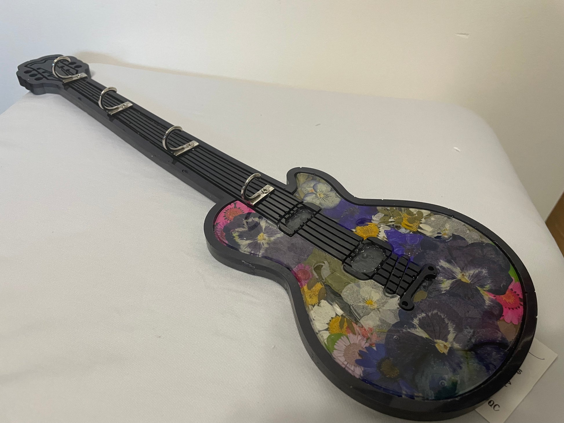 Floral-patterned guitar-shaped object on a white surface
