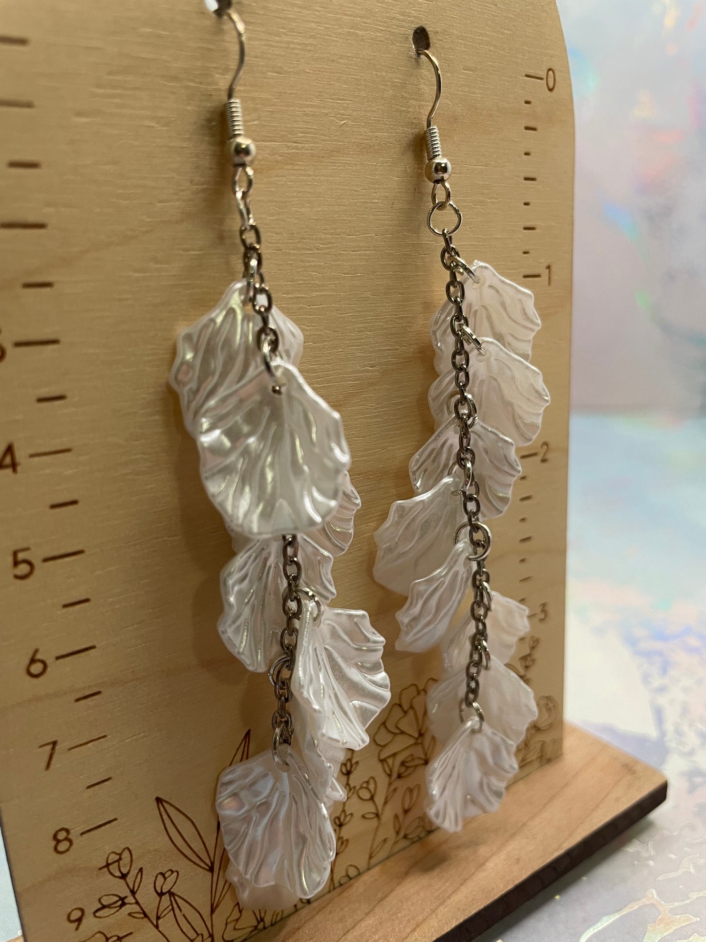 10.3cm-White Flower Petal Acrylic Dangle Earrings on a wooden surface with a ruler for scale.