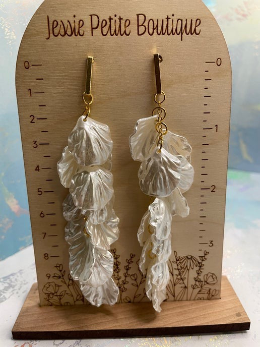 Leaf-shaped earrings on a wooden display card with 'Jessie Petite Boutique' branding.