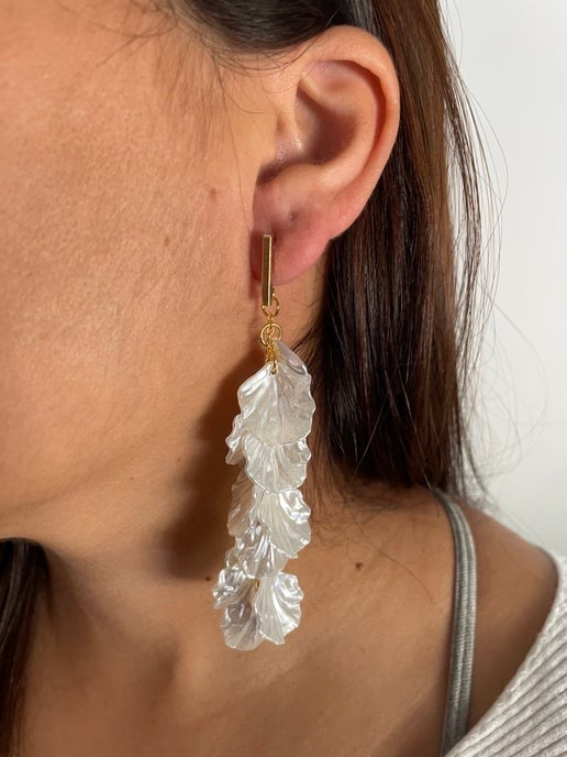 Close-up of a person wearing a leaf-shaped earring 