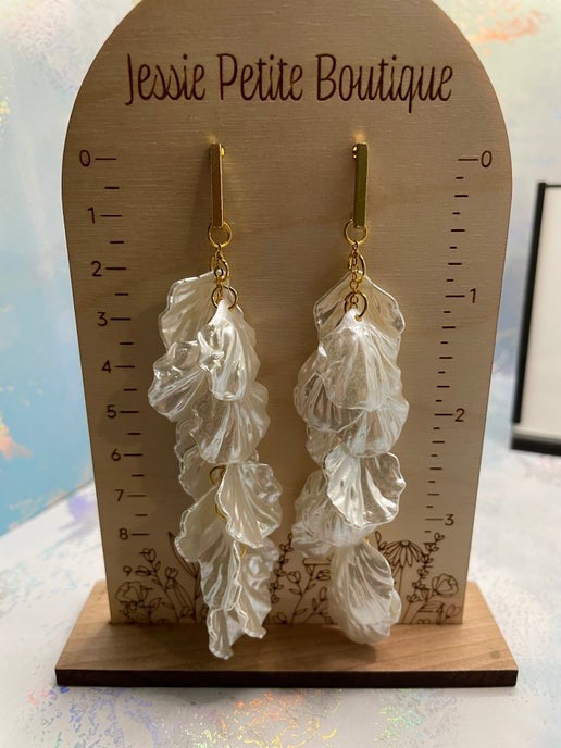 Leaf-shaped earrings on a wooden display card with 'Jessie Petite Boutique' branding.