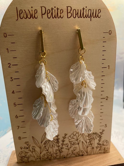 Leaf-shaped earrings on a wooden display card with 'Jessie Petite Boutique' branding.