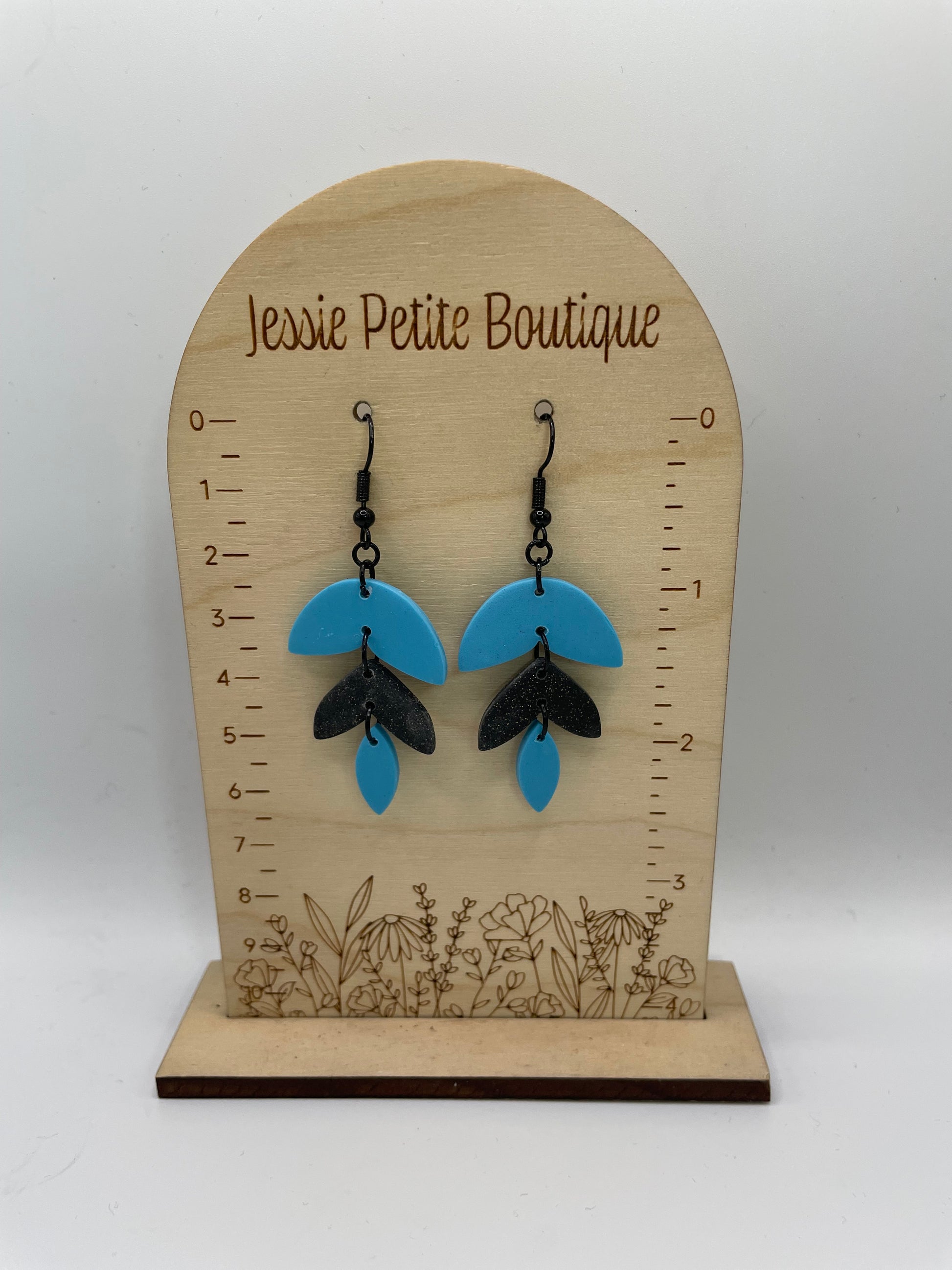 A-Alba: Black & Blue Earrings on a wooden display with 'Jessie Petite Boutique' branding.