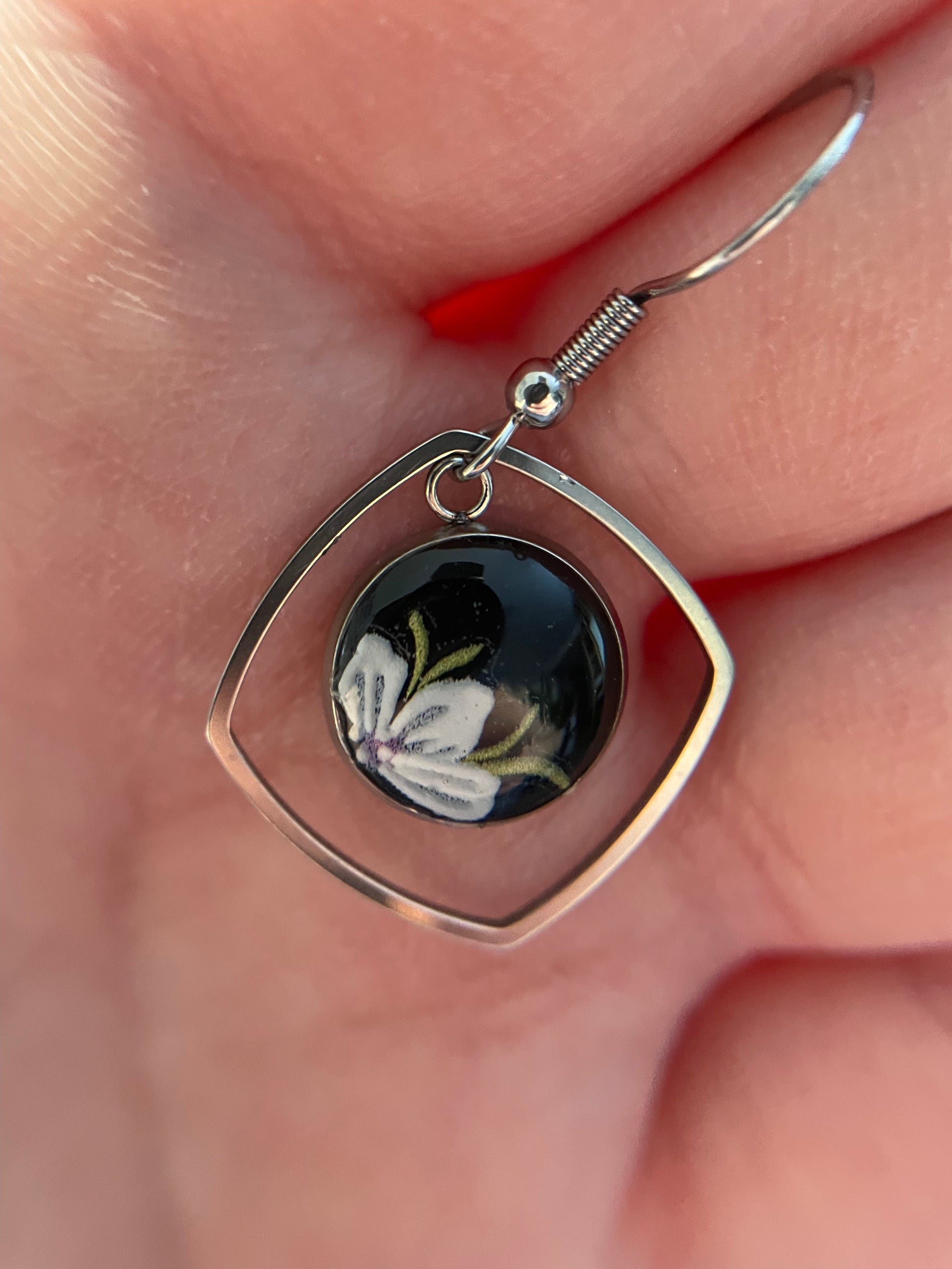 Floral Bezel with Geometric Frame held between fingers