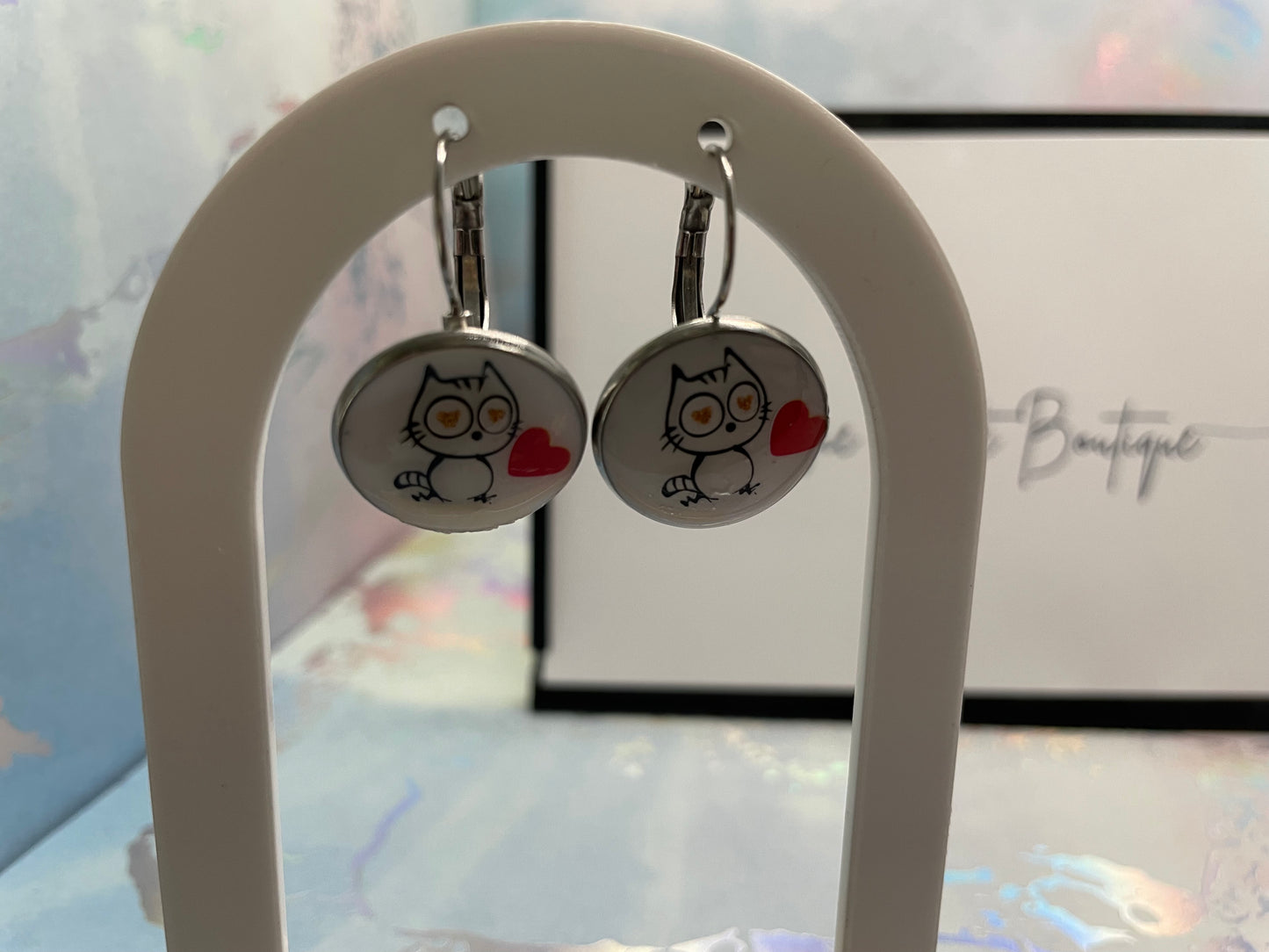 Cat-Themed Round Bezel Earrings on a white stand.