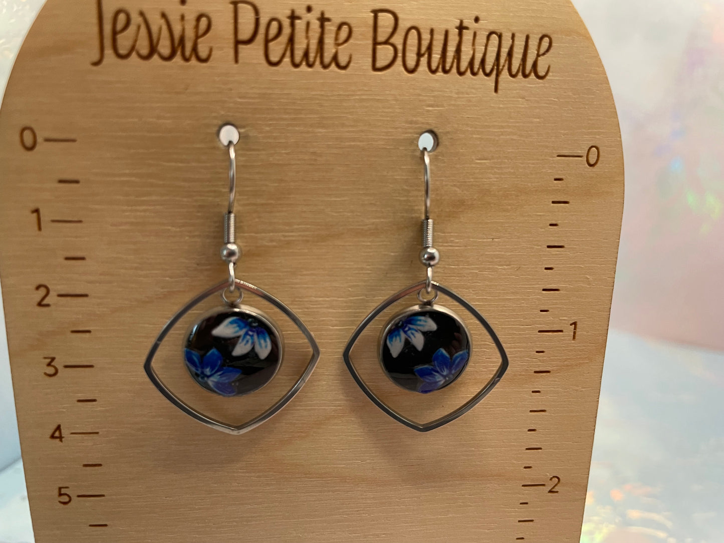 Pair of earrings on a wooden display card with 'Jessie Petite Boutique' branding.