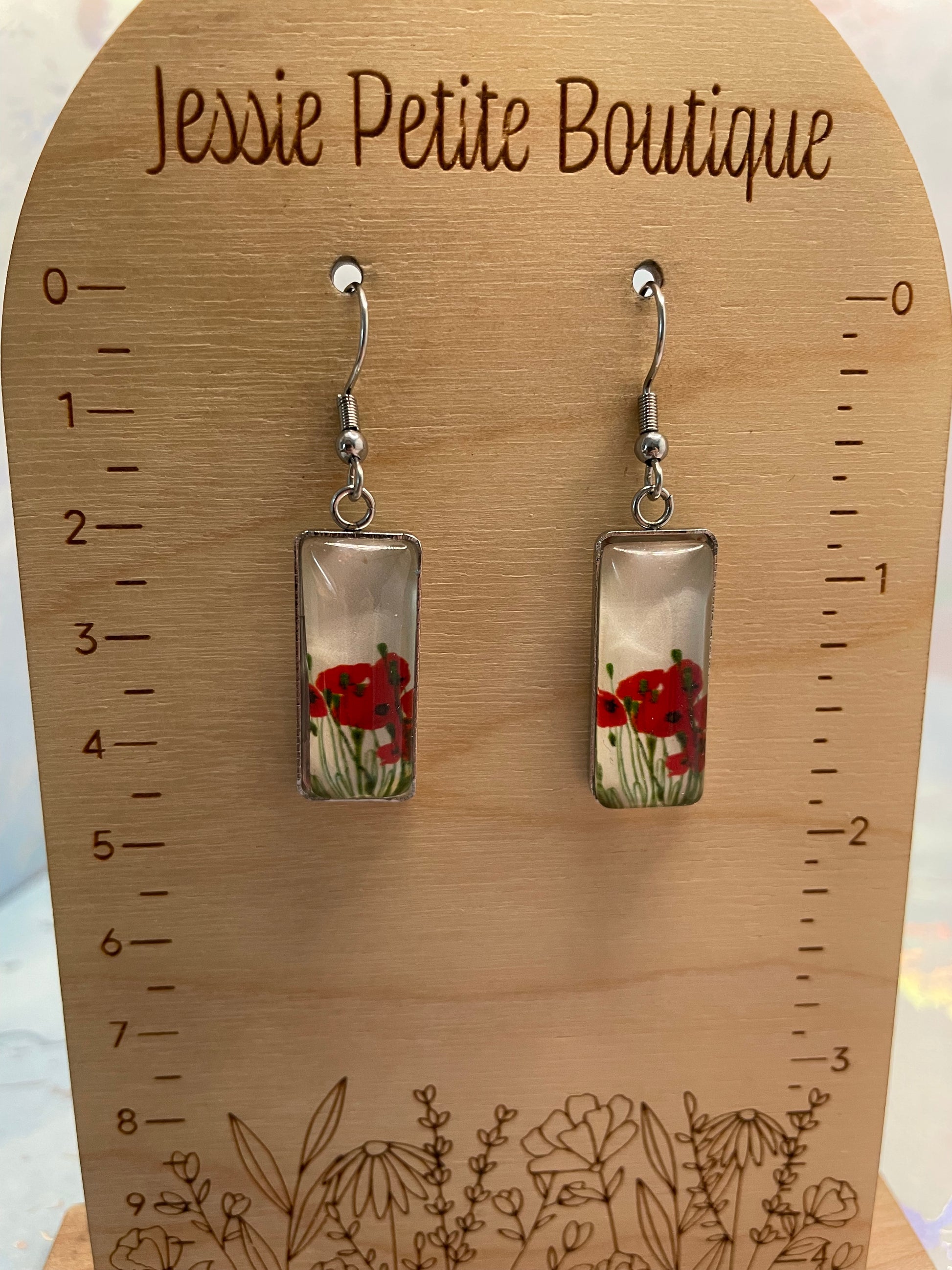Pair of earrings with floral design on a wooden ruler from Jessie Petite Boutique