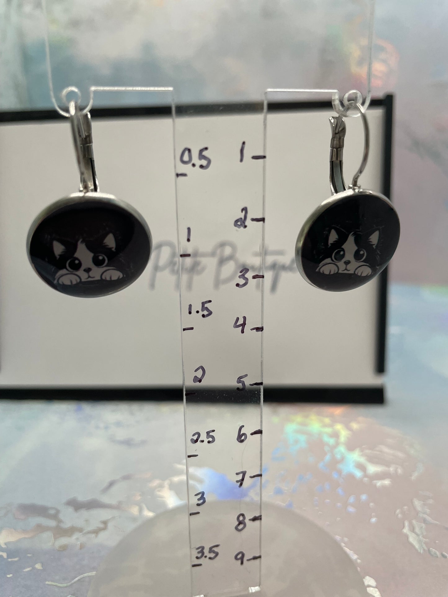 Cat-Themed Round Bezel Earrings on a ruler for scale