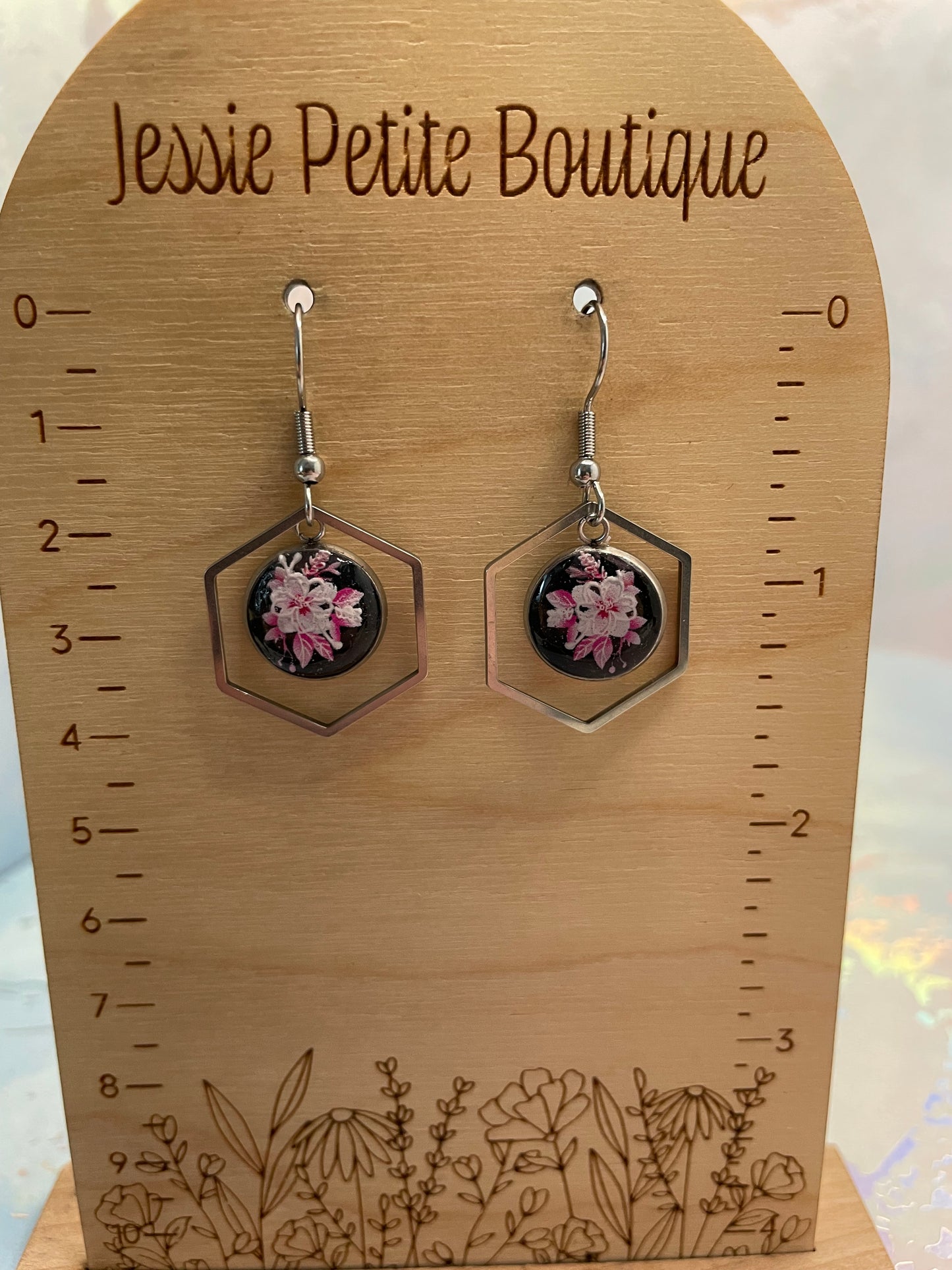 Hexagonal earrings with floral design on a wooden card with measurements and 'Jessie Petite Boutique' branding.