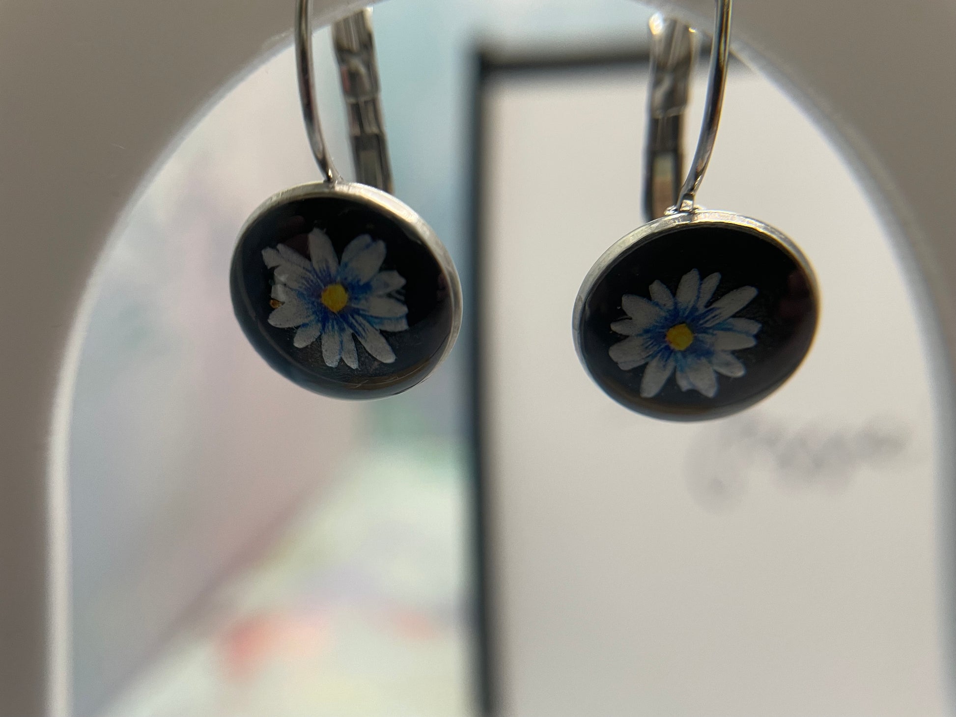 Pair of earrings with floral design on a blurred background