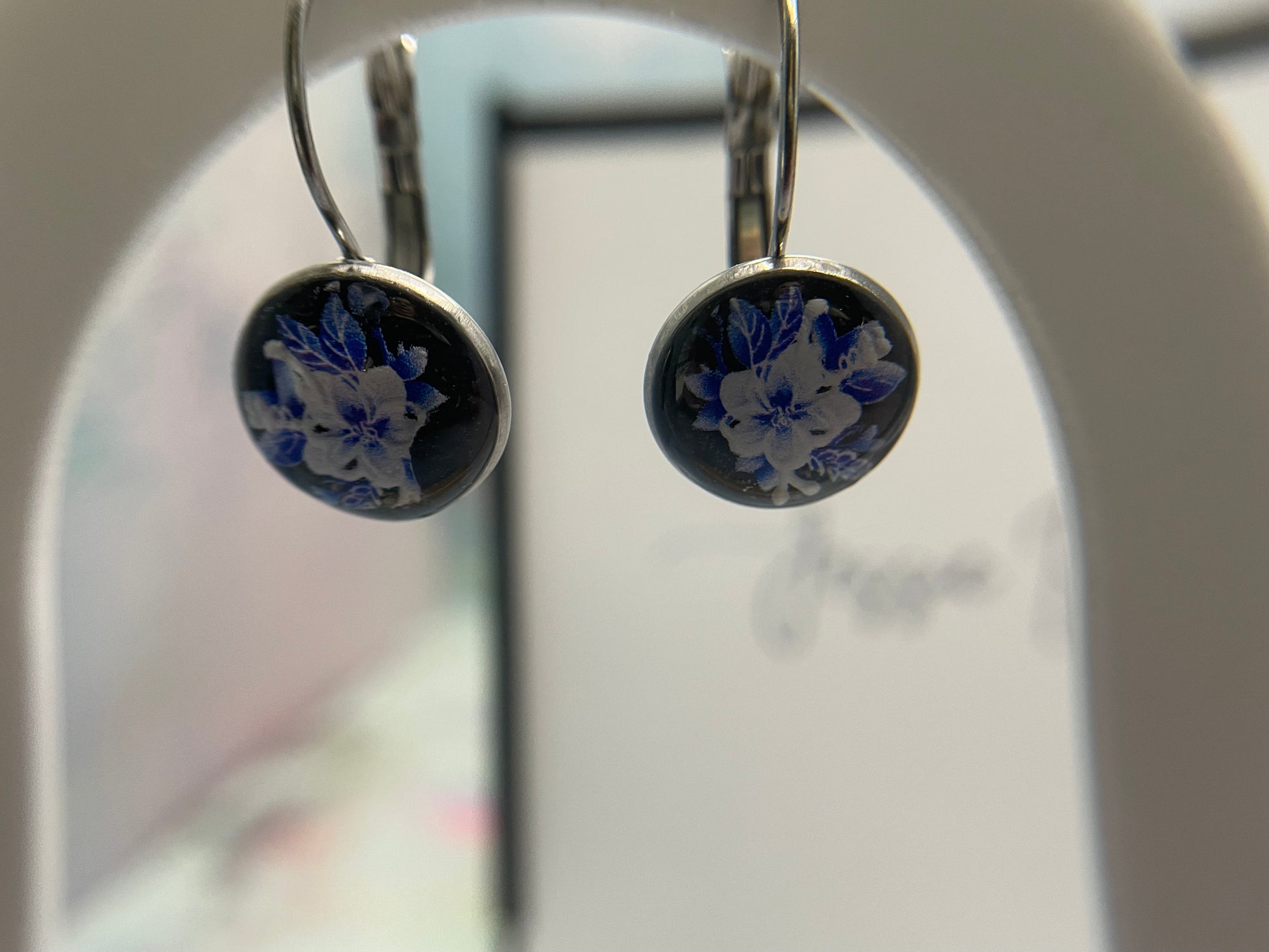 Pair of earrings with floral design on a blurred background