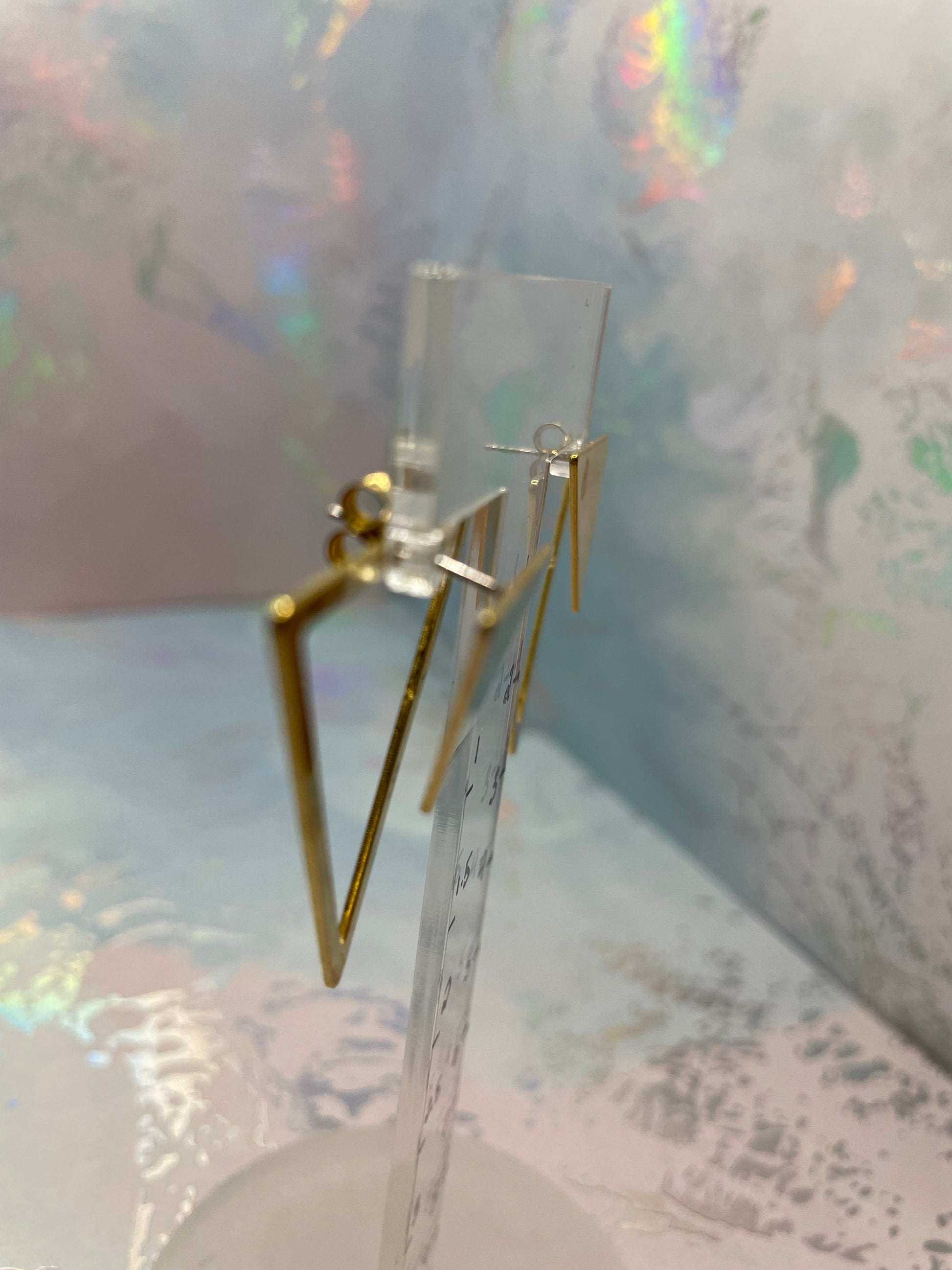 Gold earring on a light gray background