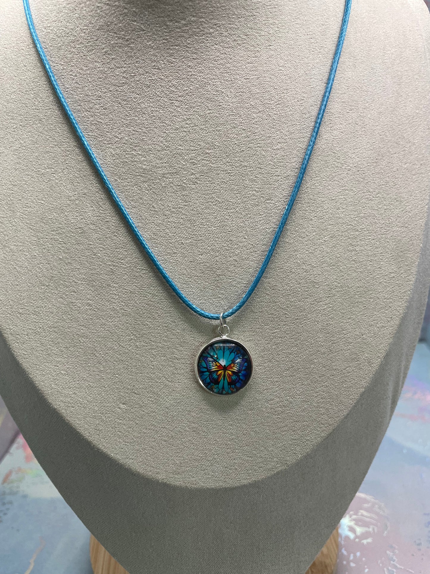 Collier cabochon papillon – corde bleu
