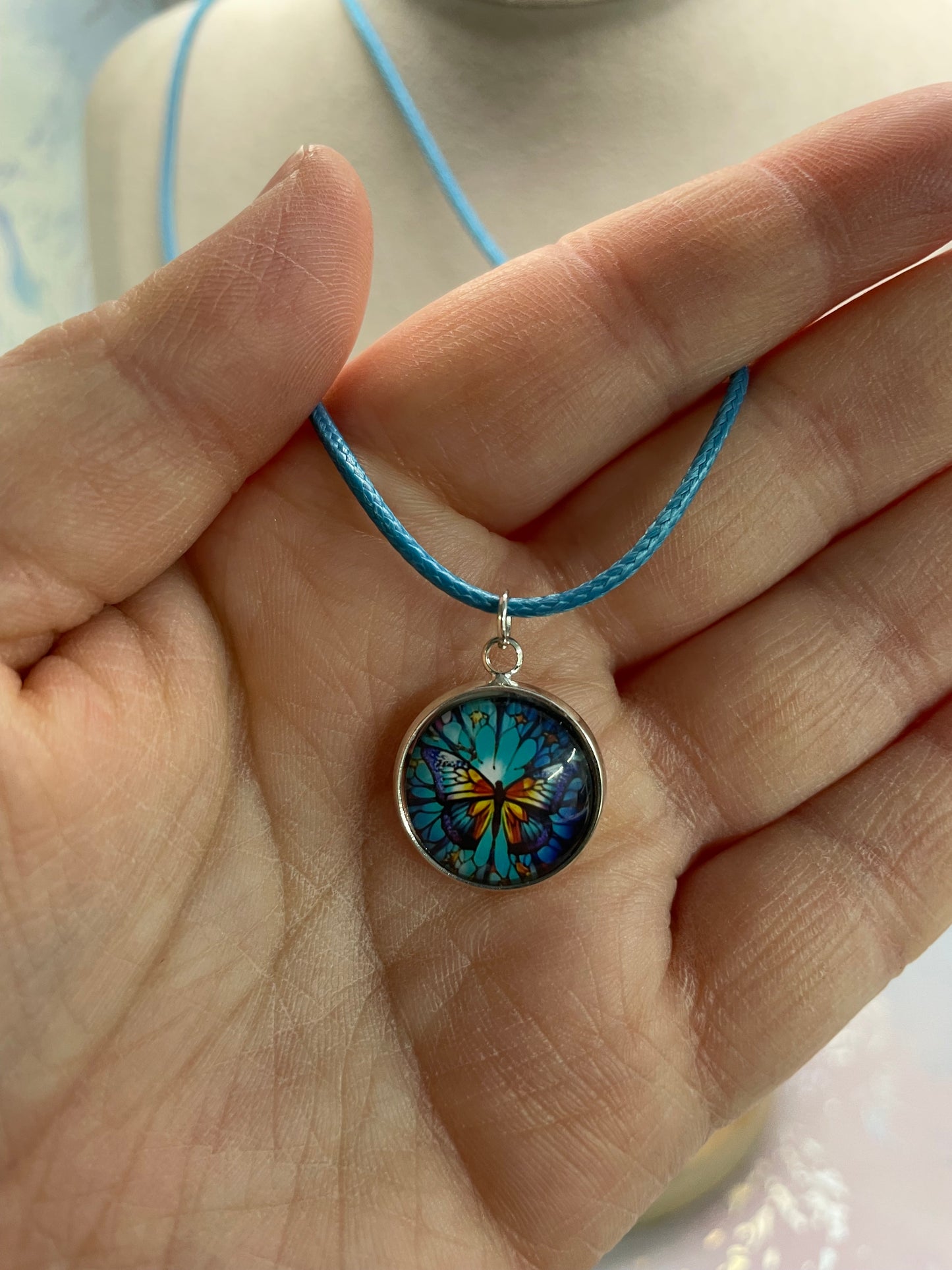 Collier cabochon papillon – corde bleu