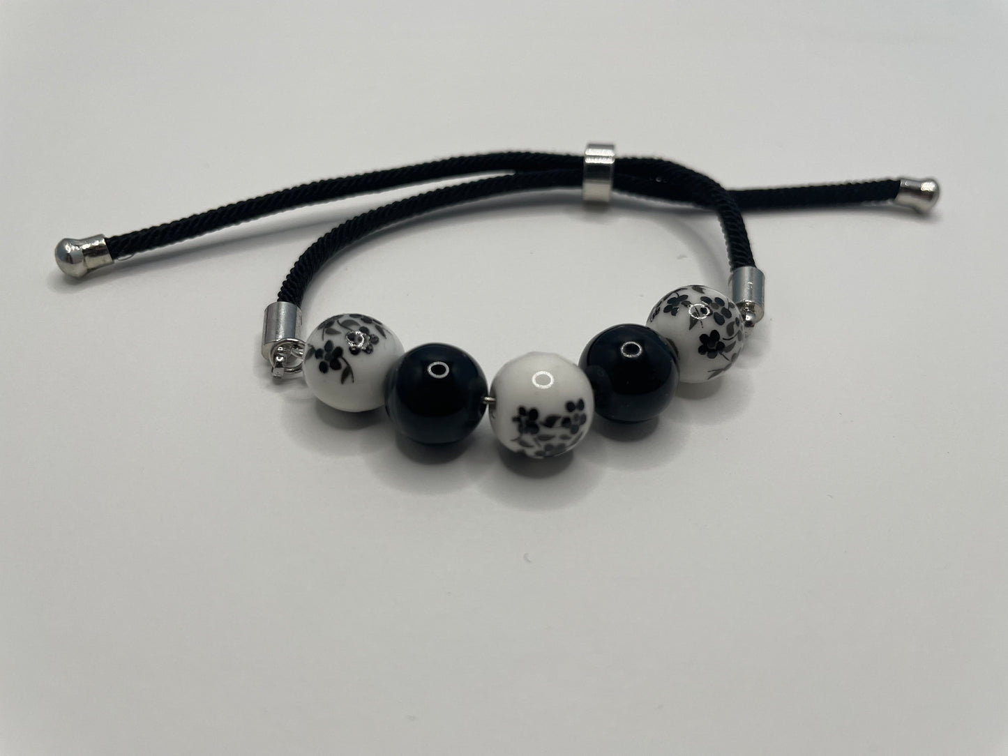 Bracelet corde ajustable billes de céramique – Noir et blanc floral