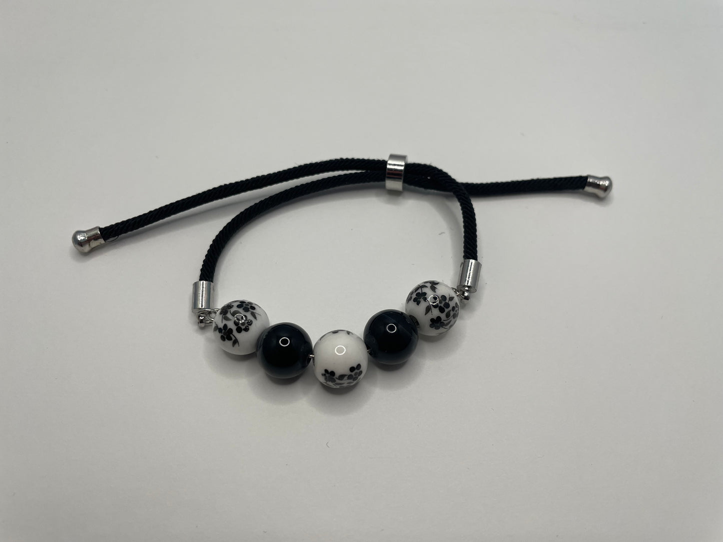 Bracelet corde ajustable billes de céramique – Noir et blanc floral