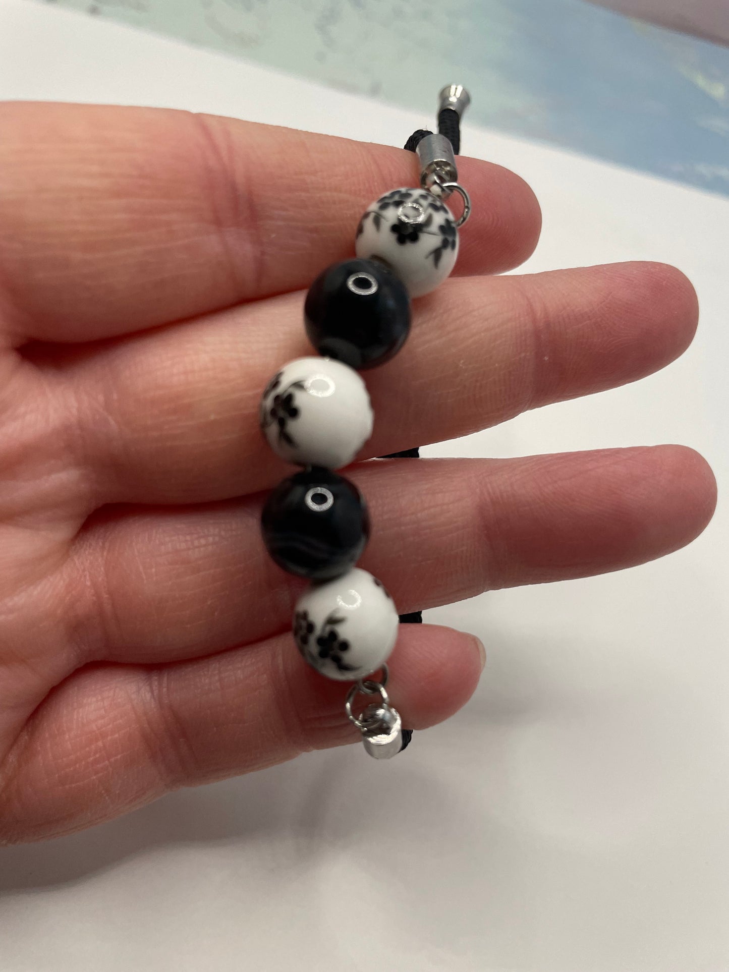 Bracelet corde ajustable billes de céramique – Noir et blanc floral