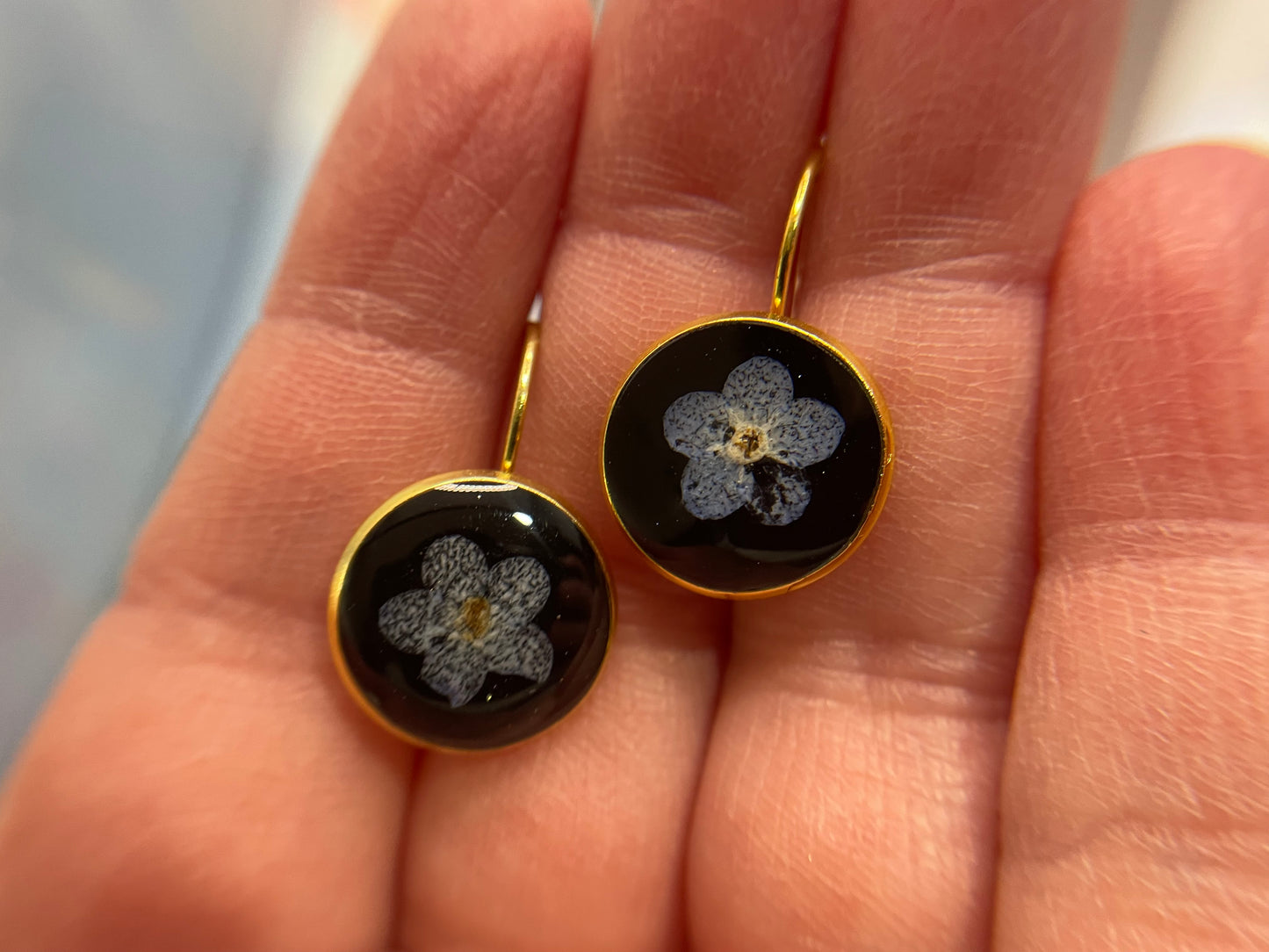Boucles d’oreilles dormeuse or avec fleur de myosotis sur noir