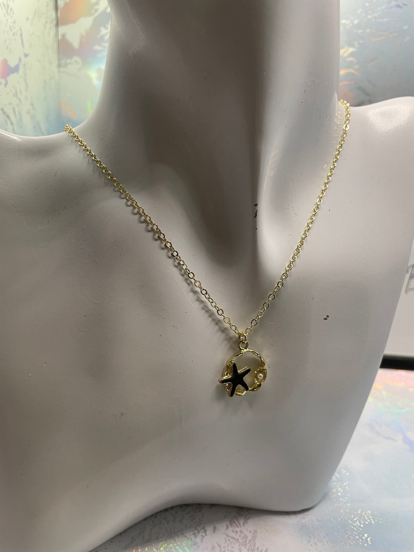 Étoile de mer noire sur cercle doré avec perles 