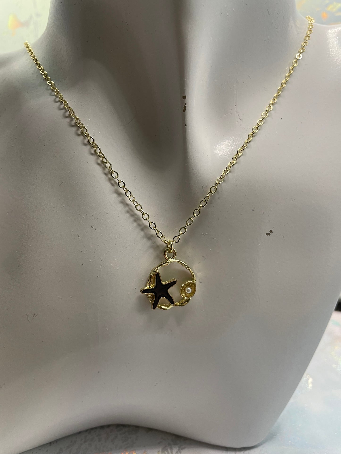 Étoile de mer noire sur cercle doré avec perles 