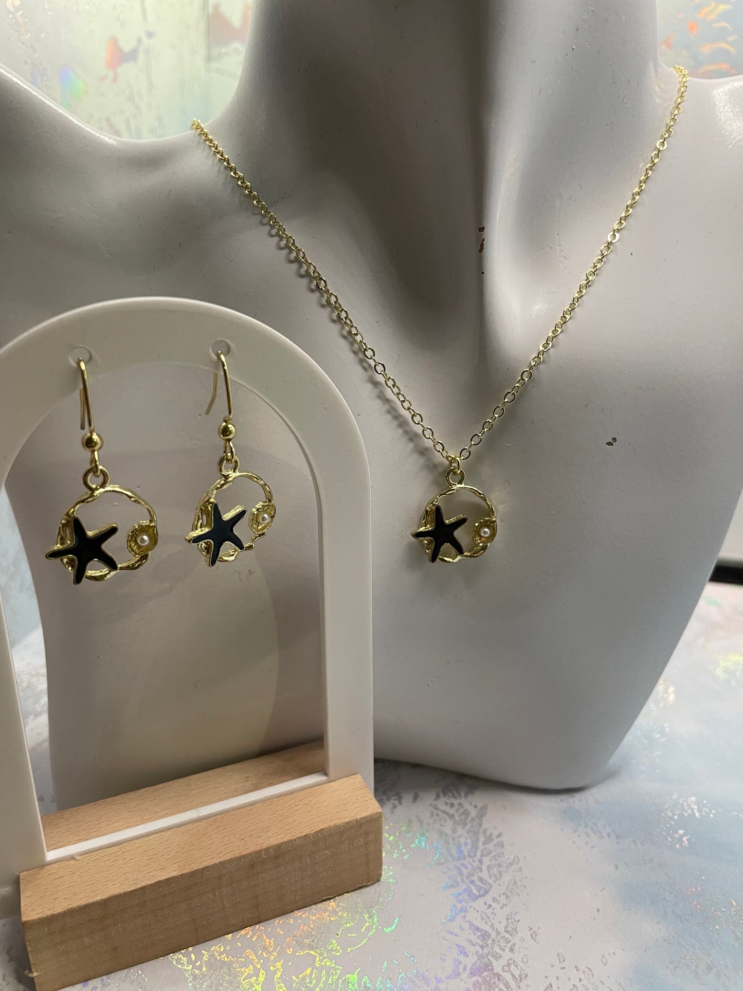 Étoile de mer noire sur cercle doré avec perles 