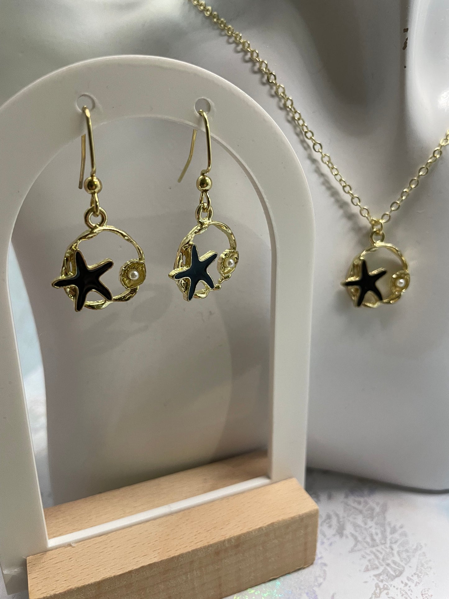 Étoile de mer noire sur cercle doré avec perles 