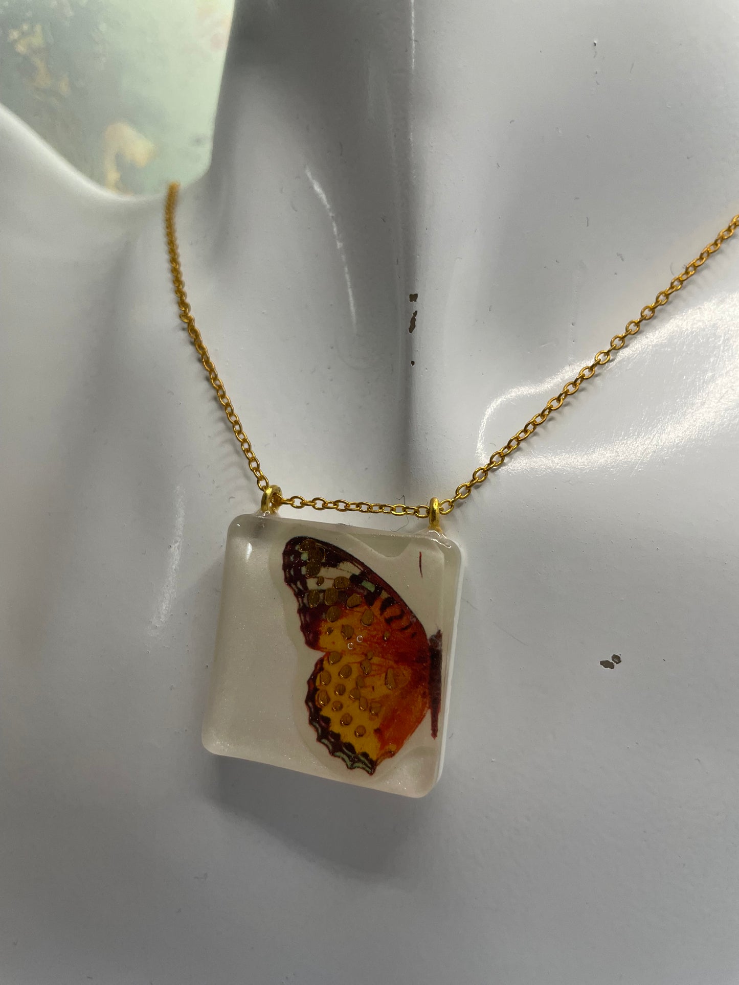 Collier Papillon orange sur carré blanc -21"