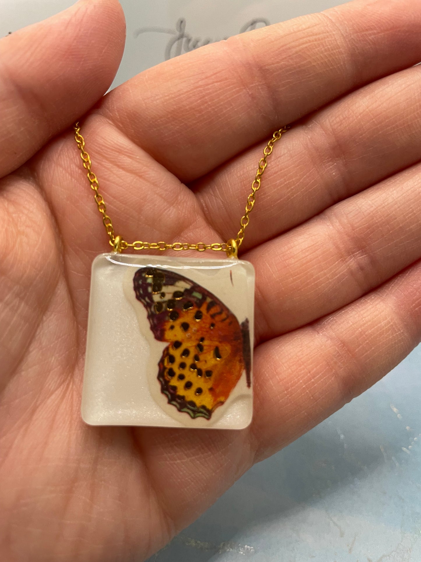 Collier Papillon orange sur carré blanc -21"