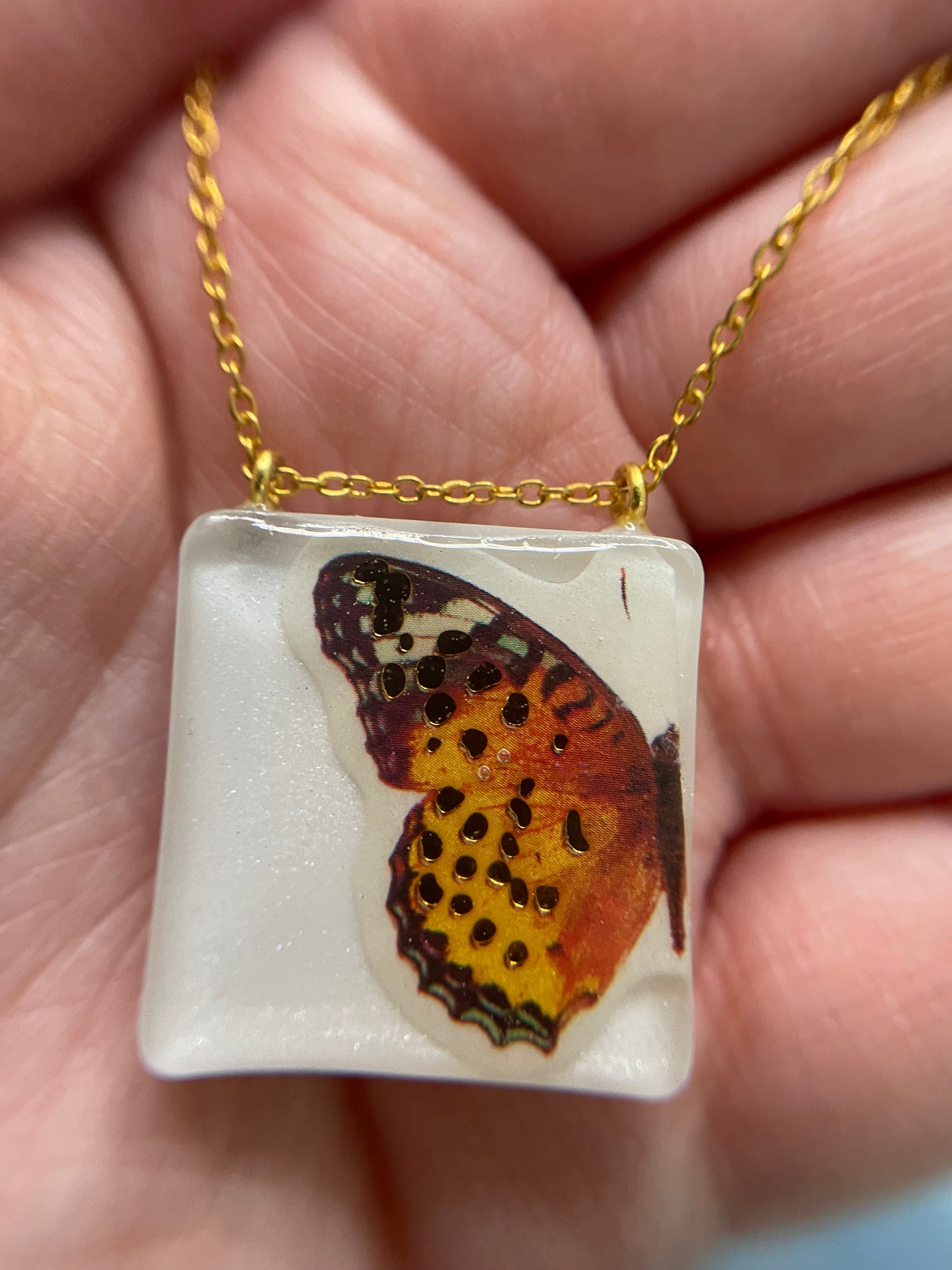 Collier Papillon orange sur carré blanc -21"