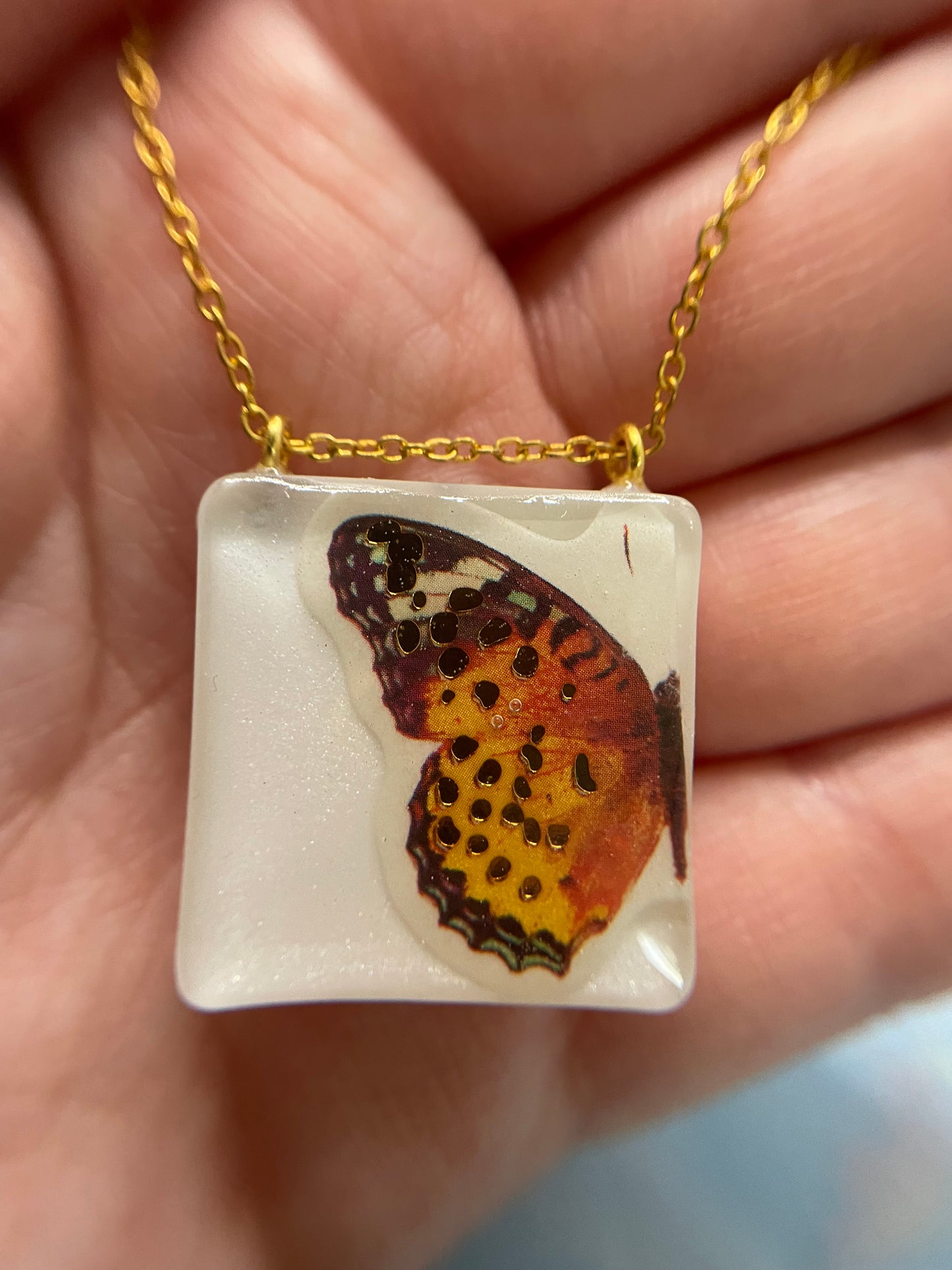 Collier Papillon orange sur carré blanc -21"