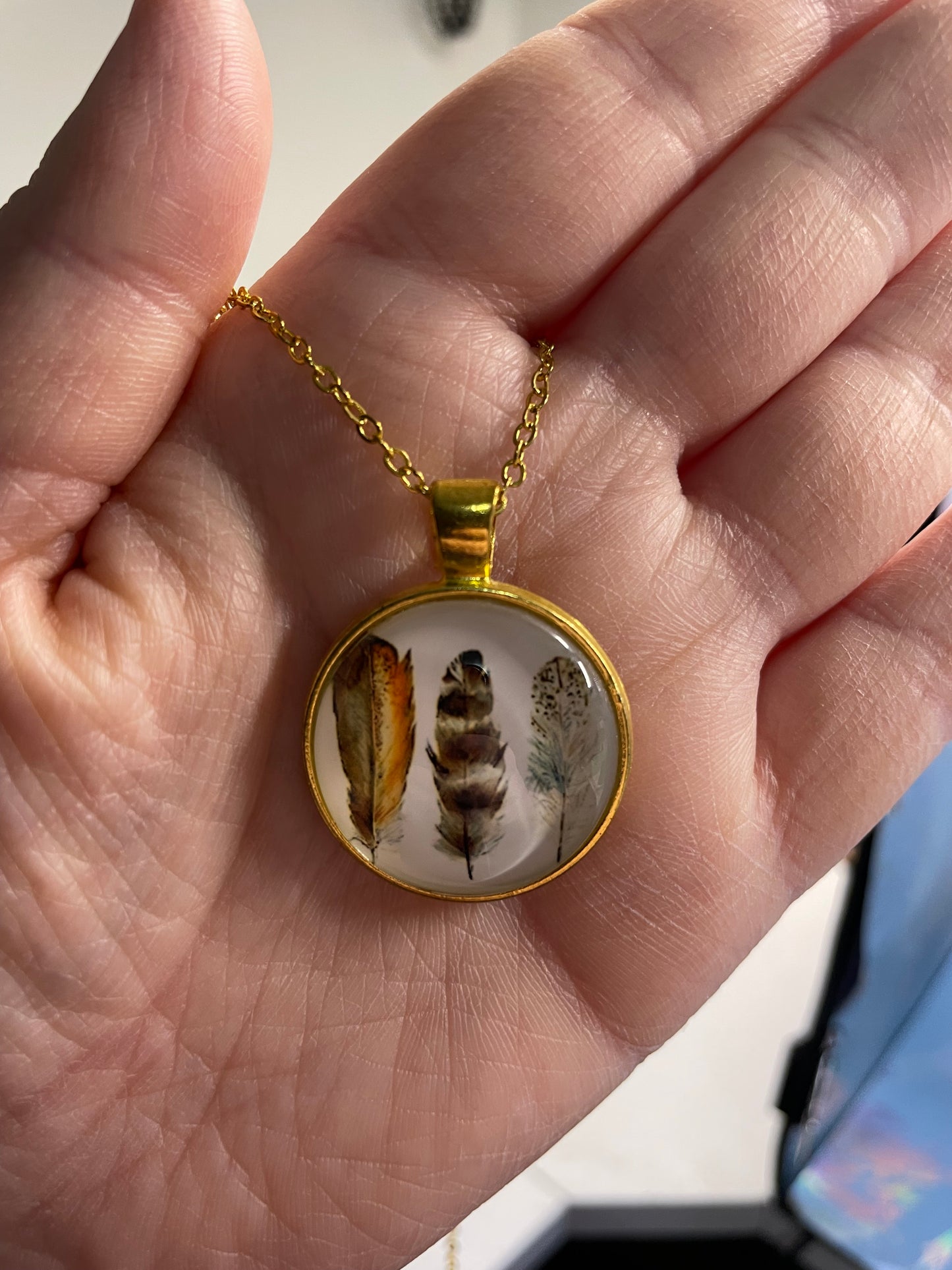 Collier cabochon doré rond à trois plumes