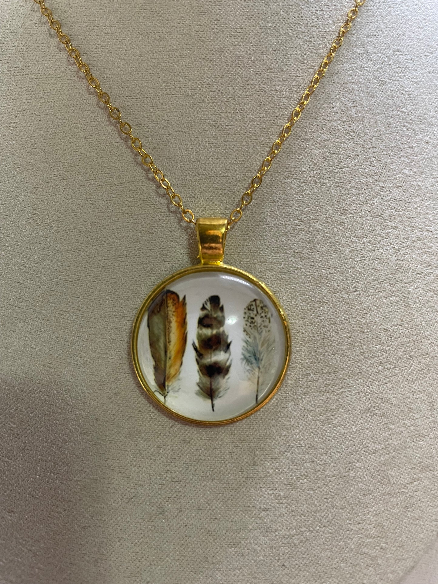 Collier cabochon doré rond à trois plumes