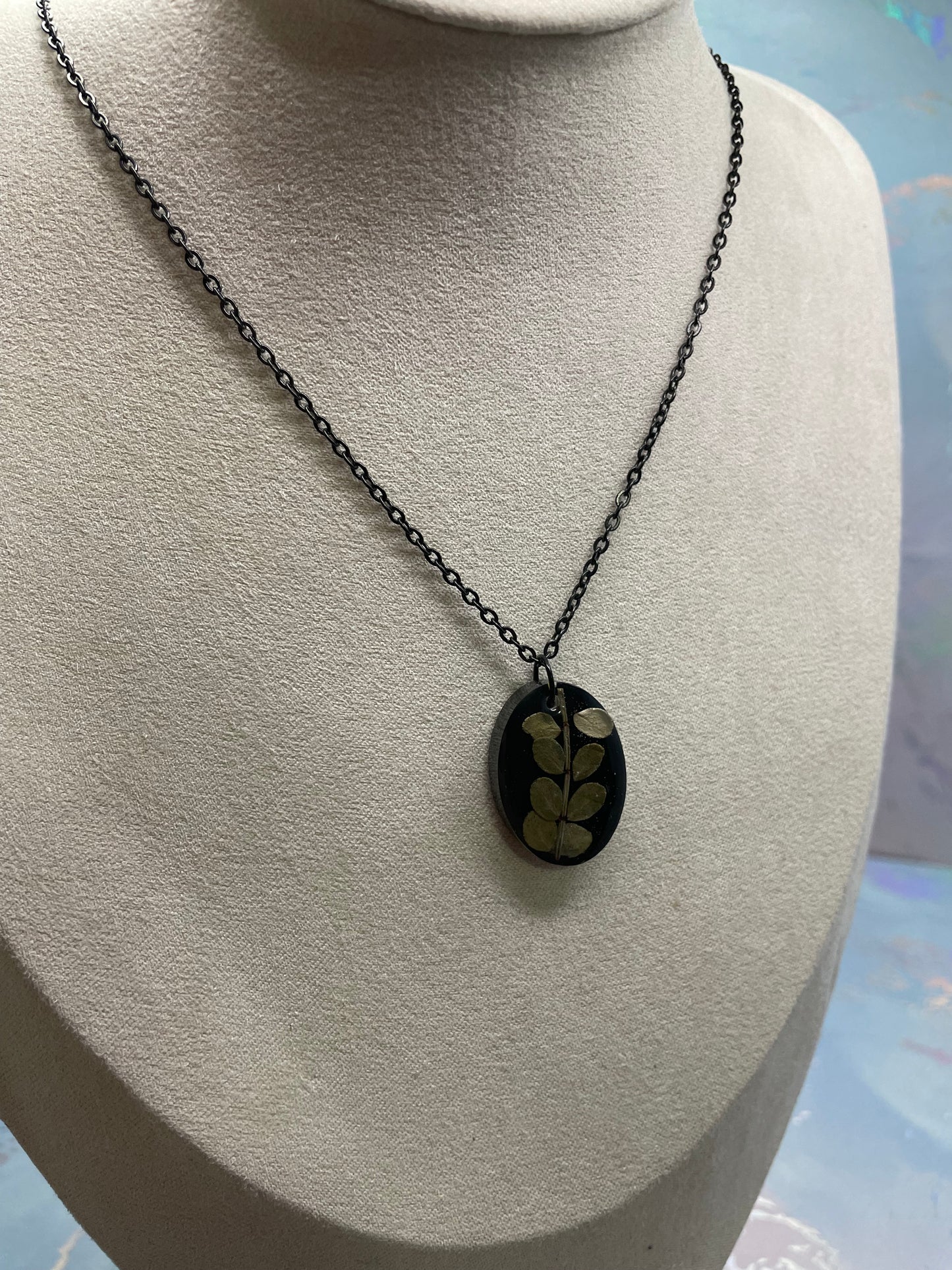 Collier ovale en résine noire avec feuillage
