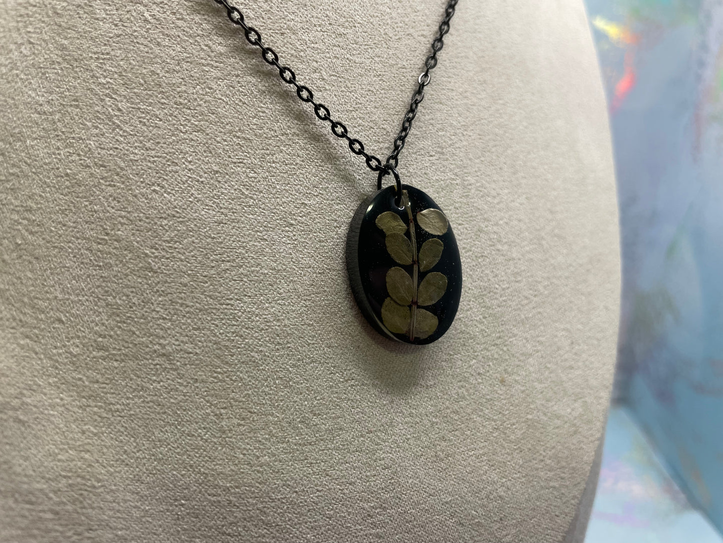 Collier ovale en résine noire avec feuillage