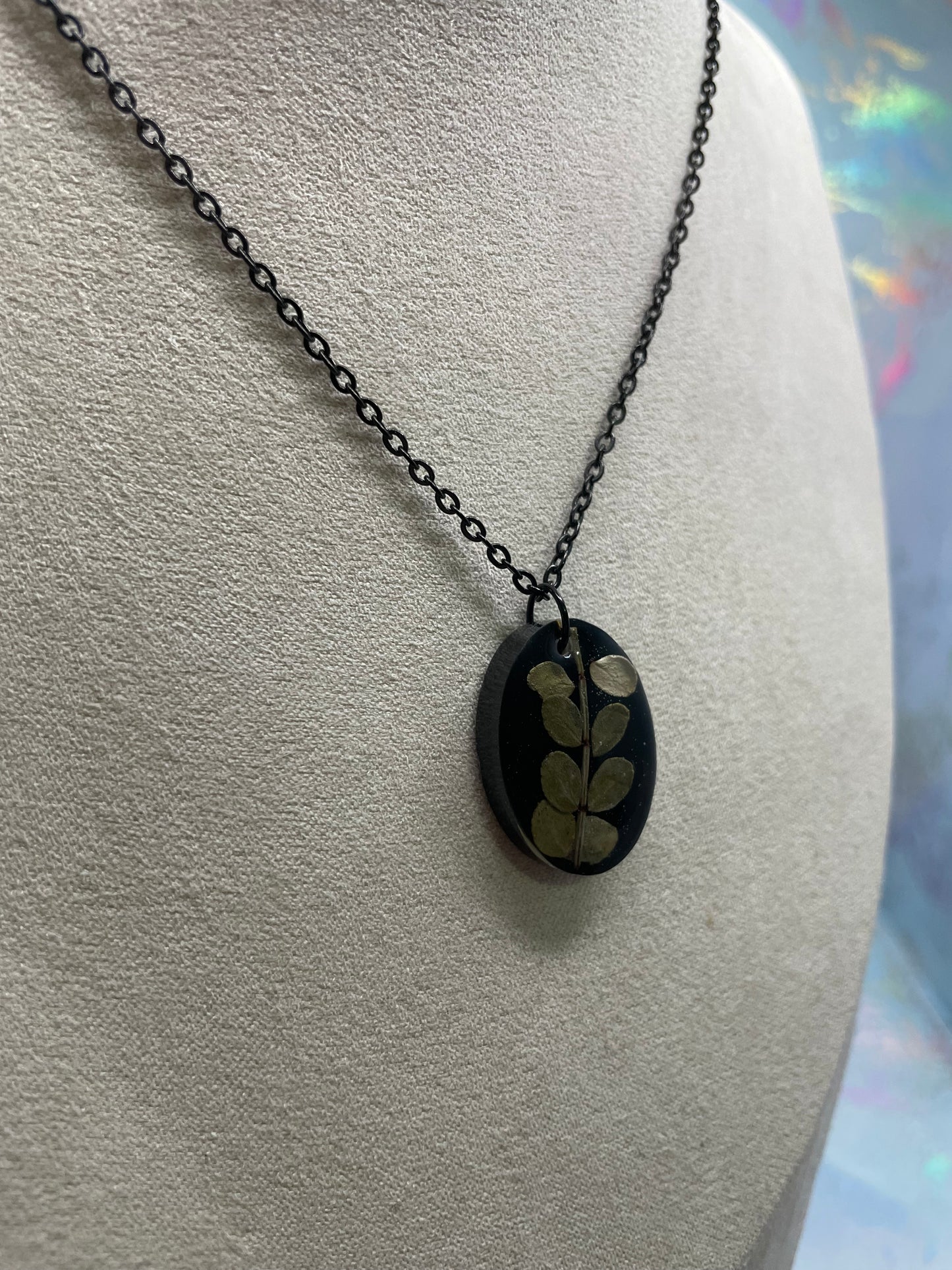 Collier ovale en résine noire avec feuillage