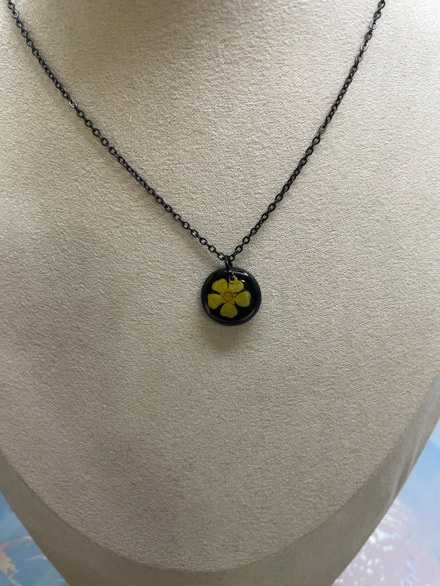 Collier petit rond fleur bouton-d’or jaune sur fond noir