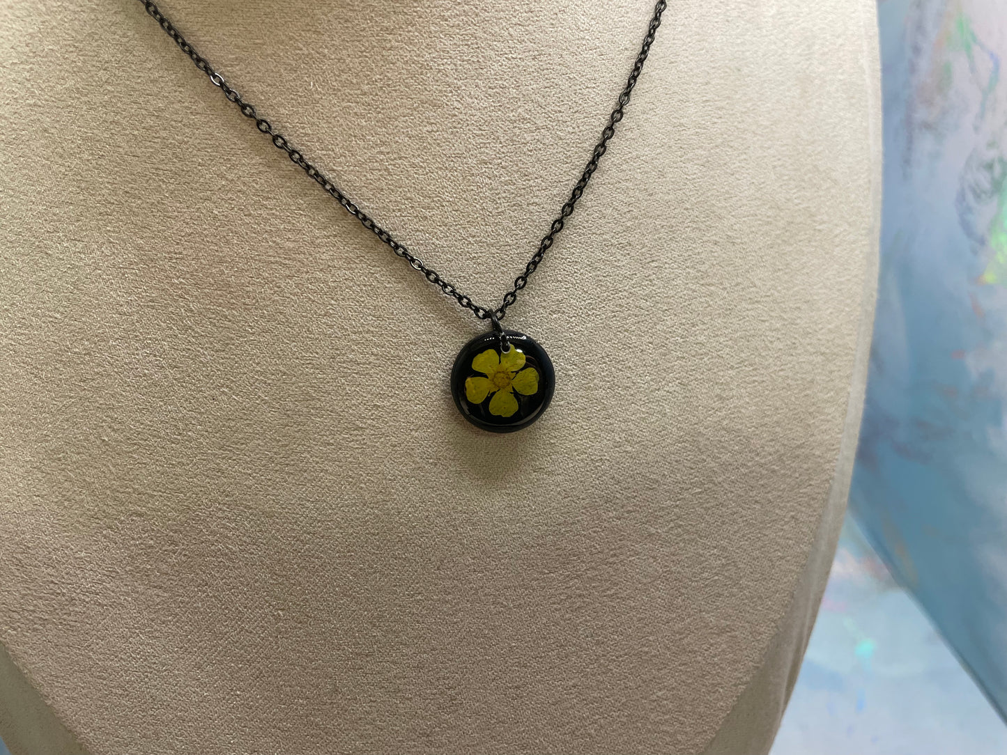 Collier petit rond fleur bouton-d’or jaune sur fond noir